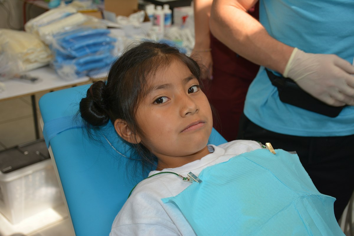 a girl sitting in a dental chair