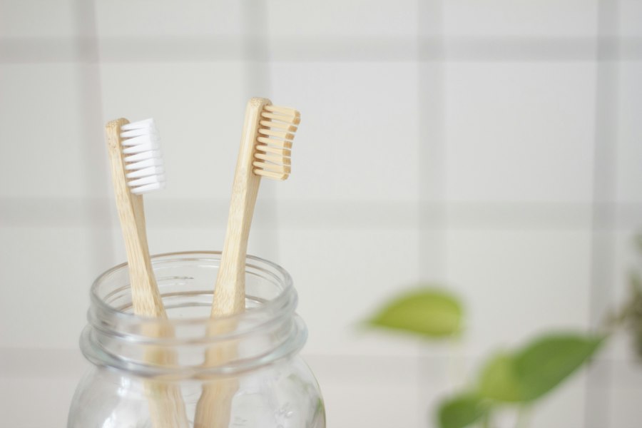 Two bamboo toothbrushes in a glass jar